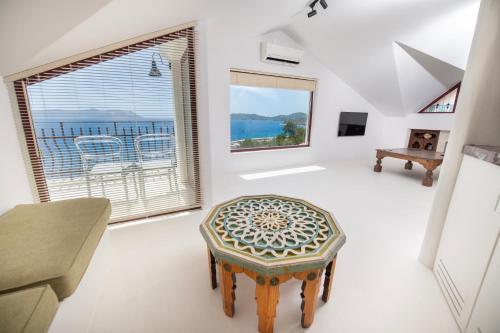 a living room with a chair and a window at Hotel Begonvil in Kaş
