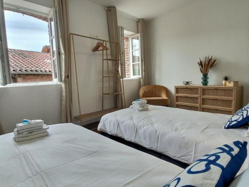 - 2 lits dans une chambre avec une fenêtre et une commode dans l'établissement Le Lautrec - Vue Cathédrale - Centre-Ville, à Albi