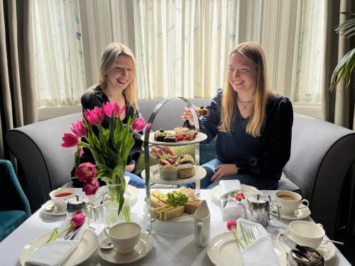 two women sitting at a table with food at Hotel Collingwood BW Signature Collection in Bournemouth