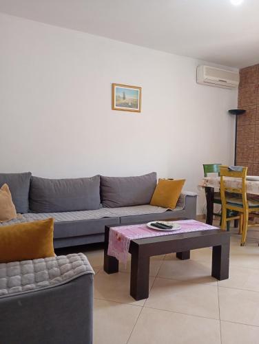 una sala de estar con un sofá y una mesa en VLORE 1+1, en Vlorë