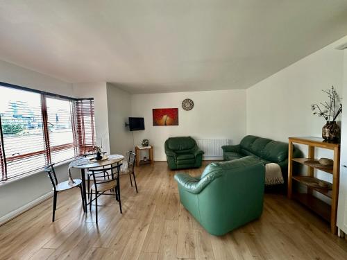 a living room with a green couch and a table at Old Town Apartment in Waterford