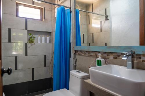 a bathroom with a white toilet and a sink at Island Lyfe Adventures in El Nido