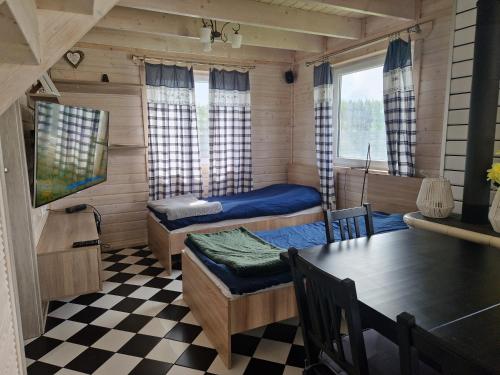 Domek Skandynawski في Przykona: غرفة بسريرين وطاولة في غرفة