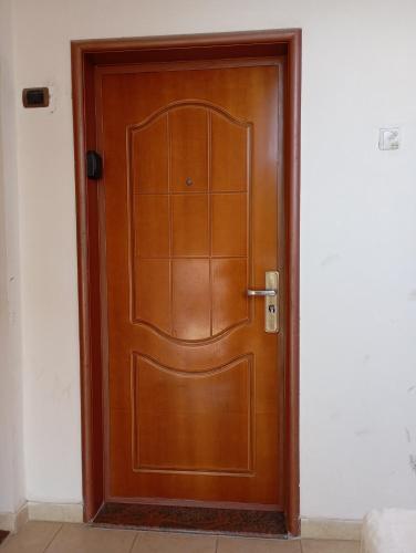 porta marrone in legno in una stanza bianca di VLORE 1+1 a Vlorë