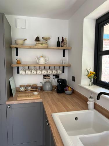 a kitchen with a tub and a sink and a counter at Bee Cottage - Romsey in Romsey