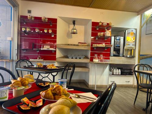 a kitchen with two tables with plates of food at Hôtel Le Bon Accueil in Porto Ota