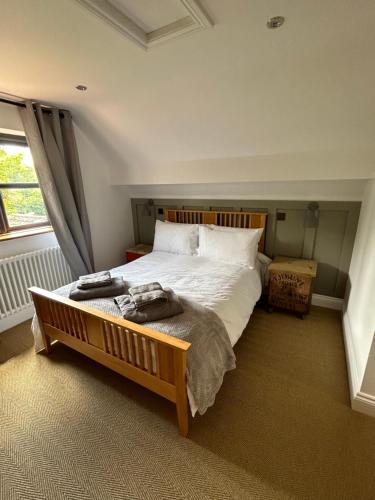 a bedroom with a large bed and a window at Bee Cottage - Romsey in Romsey