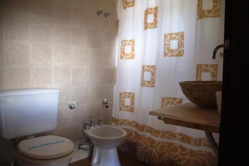 a bathroom with a toilet and a sink at Cabañas El Rincón del Golf in Sierra de la Ventana