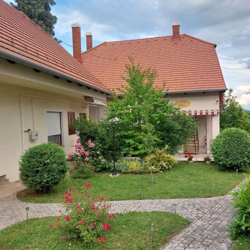 a house with a red roof and some flowers at Erika Apartmanházak in Hévíz