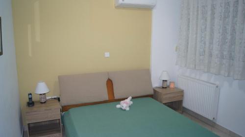 a bedroom with a green bed and two night stands at Electra in Saronida