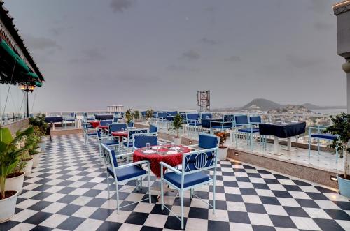 a patio with a table and chairs on a roof at Hotel Darbargarh, Udaipur in Udaipur