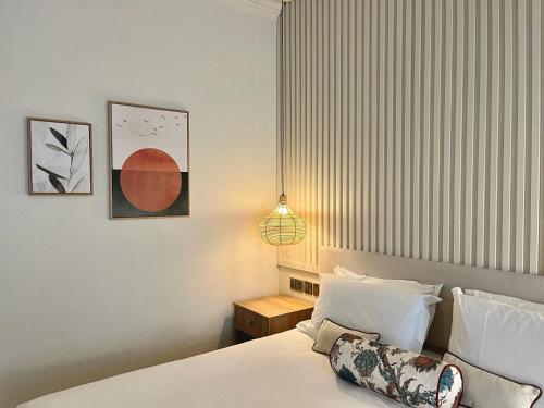 a bedroom with a bed with white sheets and a lamp at Hotel Collingwood BW Signature Collection in Bournemouth