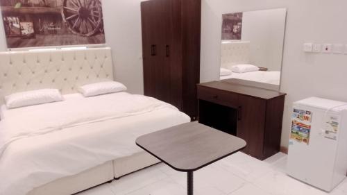 a bedroom with a bed and a desk and a mirror at جوهرة البيعة للوحدات السكنية in Taif