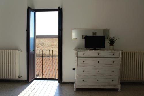 a room with a dresser with a television and a balcony at Il Castello di Atessa in Atessa