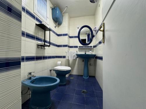 a bathroom with a blue toilet and a sink at suite cubè al centro storico vicino la scuola Vespucci con parcheggio su richiesta in Frattamaggiore