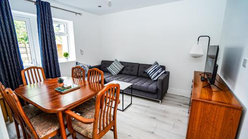 a living room with a table and a couch at Spacious 4Bedroom House with Complimentary Parking in Slough