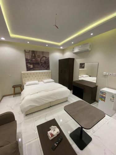 a bedroom with a large bed and a desk at جوهرة البيعة للوحدات السكنية in Taif