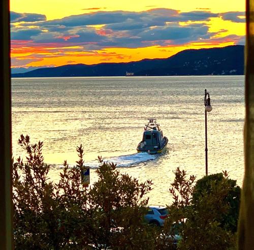 una piccola barca in acqua al tramonto di Five Flowers Guest House - self check-in a Trieste