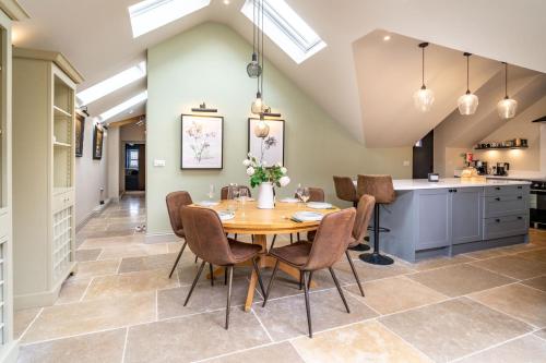 a kitchen and dining room with a table and chairs at Knyvetts sleeps 6, 3 double beds, pretty garden in North Creake
