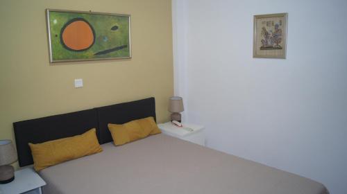 a bedroom with a large bed with yellow pillows at Electra in Saronida