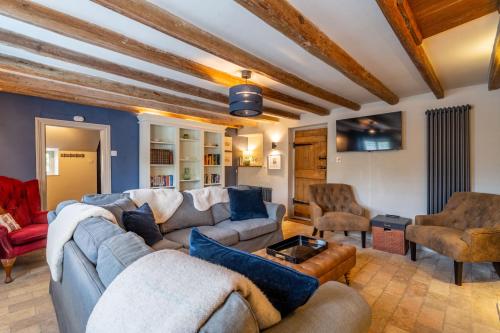 a living room with couches and chairs at Knyvetts sleeps 6, 3 double beds, pretty garden in North Creake