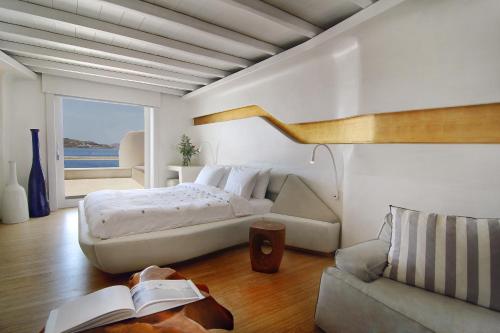 una camera con un grande letto e un divano di Cavo Tagoo Mykonos a Mykonos Città