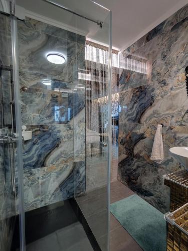 a bathroom with a shower with a stone wall at Romantisches Bergapartment - Luxus Studio auf der Simonhöhe in Zirkitz