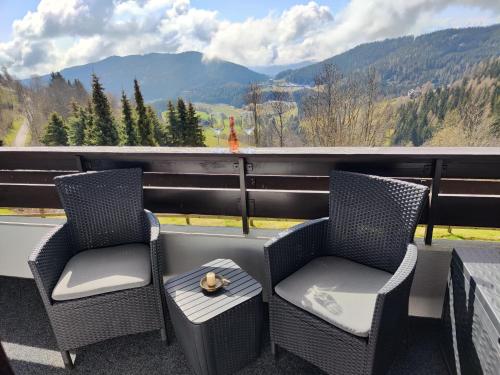 two chairs on a balcony with a view of mountains at Romantisches Bergapartment - Luxus Studio auf der Simonhöhe in Zirkitz