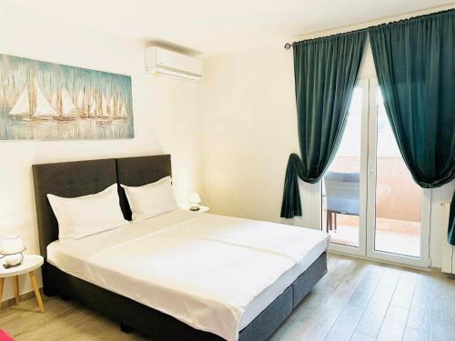 a bedroom with a bed and a large window at Apartmani MARCO,LUKAS,PATRICK,DAVID,blizu centra i mora sa FREE privatnim parkingom in Pula