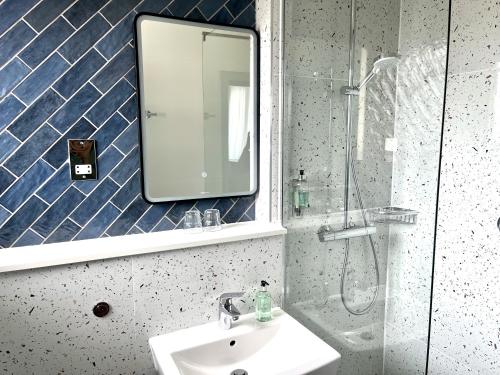 a bathroom with a sink and a mirror and a shower at Hotel Collingwood BW Signature Collection in Bournemouth