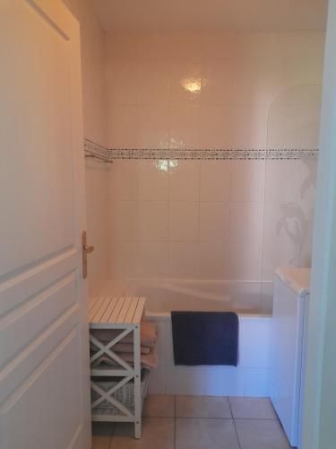 La salle de bains est pourvue d'une baignoire et d'une table. dans l'établissement Appartement avec jardin au pied de l'alpe d'huez, à La Garde