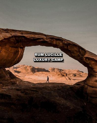 a person walking through an arch in the desert at Rum Lucille Luxury camp in Wadi Rum