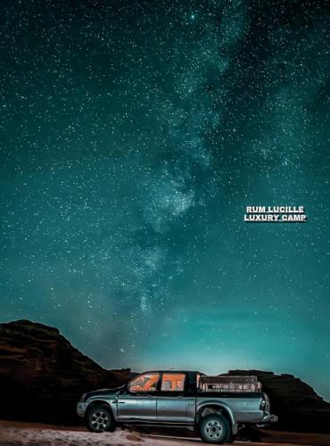 a green truck parked under a starry sky at Rum Lucille Luxury camp in Wadi Rum