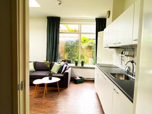 a kitchen and living room with a couch and a table at Huisje De Deining in Ermelo