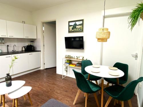 a kitchen and dining room with a table and chairs at Huisje De Deining in Ermelo