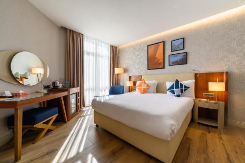 a hotel room with a large bed and a desk at Four Points Flex by Sheraton Istanbul Taksim Square in Istanbul