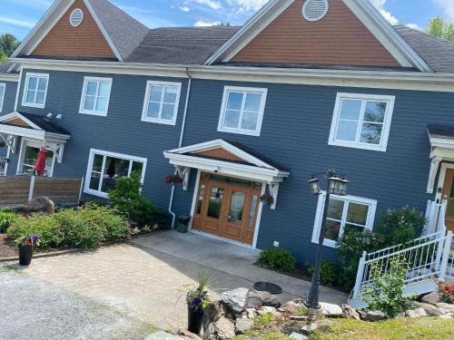 a blue house with a brown roof at Au Sommet du Lac Magog in Magog-Orford