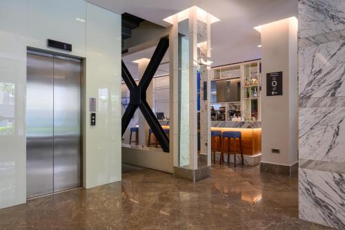 イスタンブールにあるFour Points Flex by Sheraton Istanbul Taksim Squareのガラスのドアとバーのあるロビー