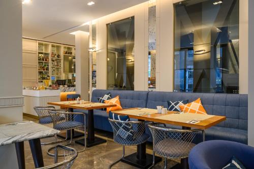 a restaurant with tables and chairs and a blue couch at Four Points Express by Sheraton Istanbul Taksim Square in Istanbul