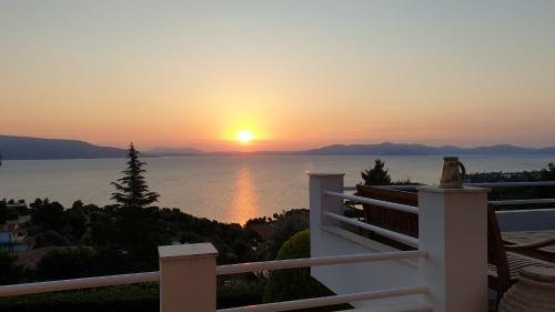 a sunset from the balcony of a house at SeaBreeze Villa in Markópoulon Oropoú