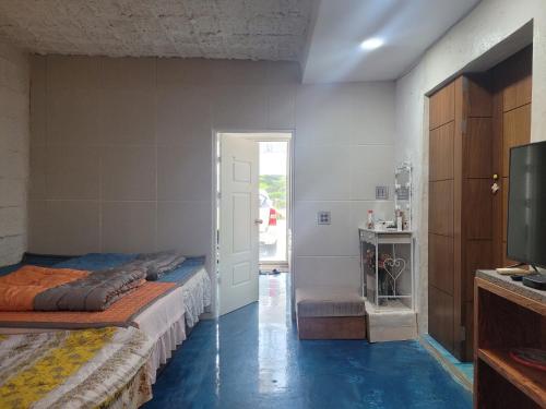 a bedroom with a bed and a television in a room at Jeju Vision House in Jeju