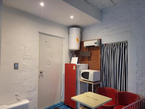 a room with a red refrigerator and a table and chairs at Jeju Vision House in Jeju