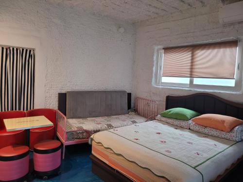 a bedroom with two beds and a window at Jeju Vision House in Jeju