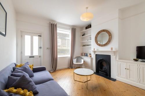 a living room with a blue couch and a fireplace at Charming Kings road in Bury Saint Edmunds