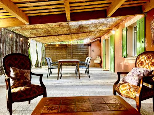 a patio with chairs and a table and a table and chairs at Domaine Plan des Devens in Roussillon