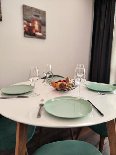 a white table with green plates and wine glasses at Familienapartment mit Pool, Spa und Panoramablick in Zirkitz