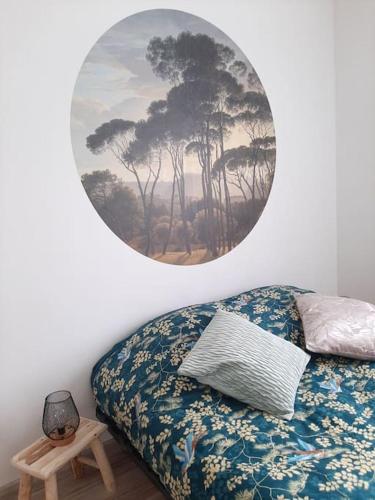 a bedroom with a bed and a painting on the wall at Proche aéroport à pied O' jungle in Tillé
