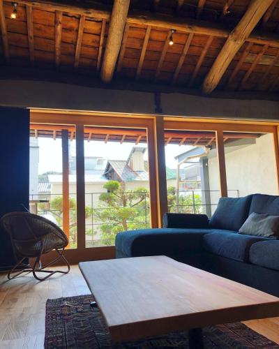 a living room with a blue couch and a table at SAVAR inn - Onomichi in Onomichi