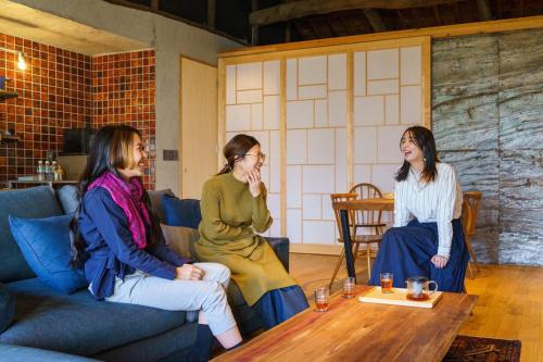 a group of three women sitting around a coffee table at SAVAR inn - Onomichi in Onomichi