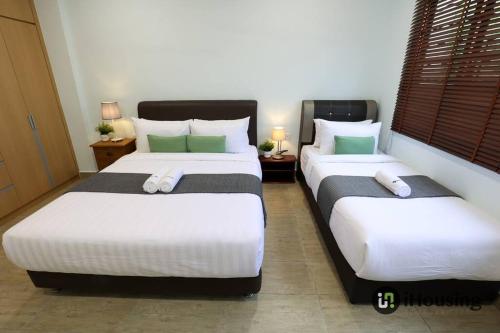 two beds in a hotel room with two pillows at Klebang Modern Classic Chill House Melaka By I Housing in Melaka